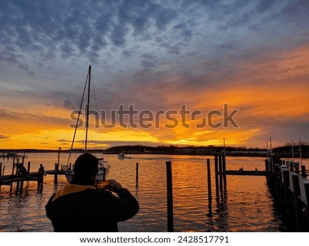 Sunset on the water with a man taking photos.