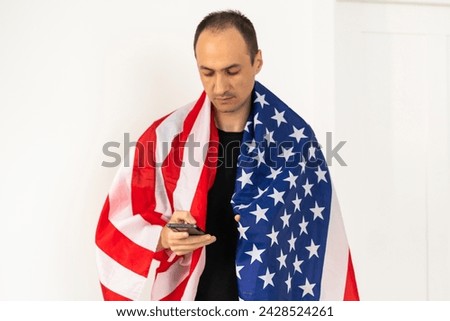 Young man holding an American flag on white background