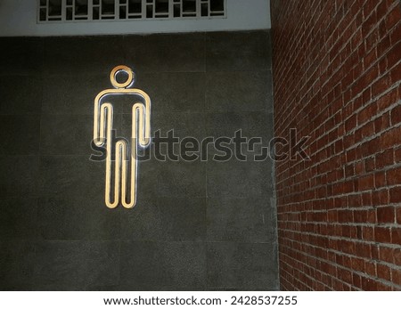 yellow modern public man toilet sign on  wall tile at the entrance. public area.