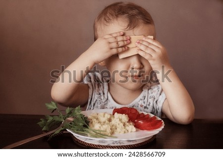 A kid eating cereals, vegetables and cheese. Healthy diet stock photo