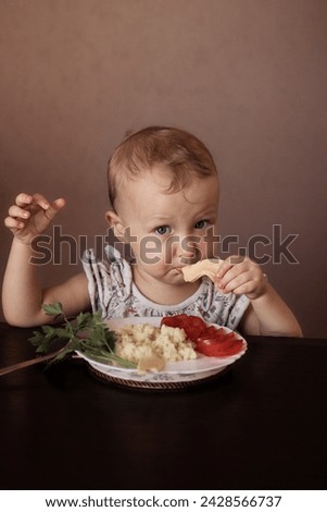A kid eating cereals, vegetables and cheese. Healthy diet stock photo