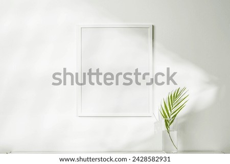 White wooden photo frame with plant leaves on white background