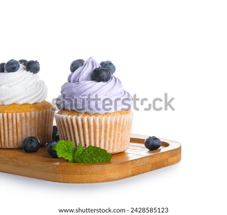 Wooden board of tasty cupcakes with blueberries on white background