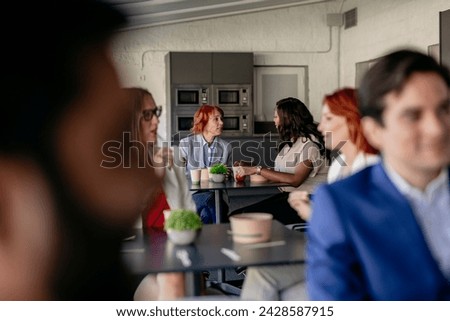 colleagues on their break time share time in the kitchen common room Royalty-Free Stock Photo #2428587915