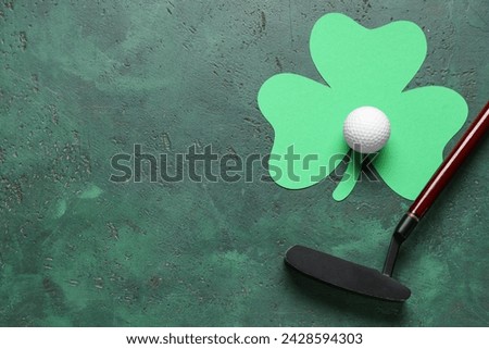 Golf club, ball and clover on green grunge background. St. Patrick's Day celebration