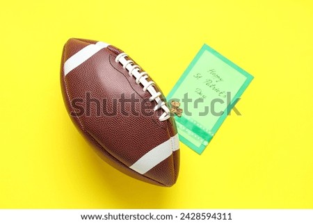 Rugby ball and greeting card on yellow background. St. Patrick's Day celebration