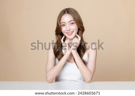 Young Asian beauty woman curly long hair with korean makeup style touch her face and perfect skin on isolated beige background. Facial treatment, Cosmetology, plastic surgery. Royalty-Free Stock Photo #2428603671