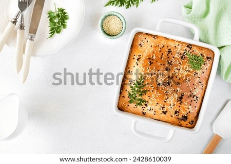 Homemade closed pie with vegetables on a white concrete background. Ingredients for a cabbage and carrot pie on the table. Copy space. Top view
