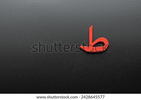 Image of Arabic letters made of wood on a black background,translation: letr ( TA )