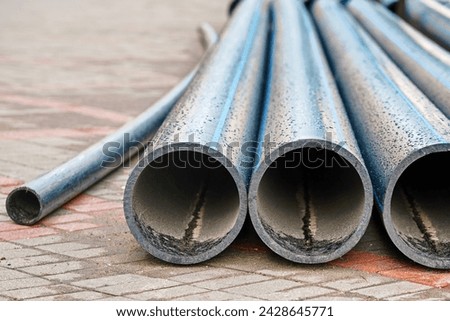 New HDPE pipes - durability and flexibility,  placed on sidewalk for the replacement, enhancement of water supply system. Infrastructure upgrade, HDPE pipes for enhanced water supply system efficiency