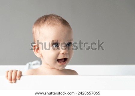 The naive look of a baby with an open mouth as an expression of the first happy emotions Royalty-Free Stock Photo #2428657065