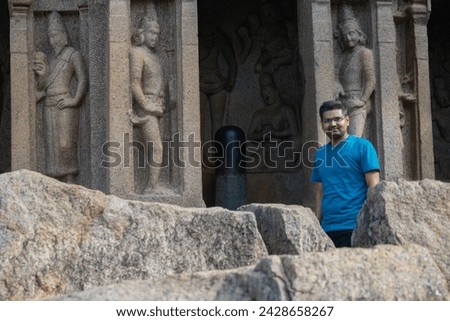 Person standing in front of temple of Lord Shiva world famous UNESCO world heritage site of Mahabalipuram. Ajanta, Ellora, Hampi ancient stone sculpture carvings sacred pilgrimage archeology tourist Royalty-Free Stock Photo #2428658267