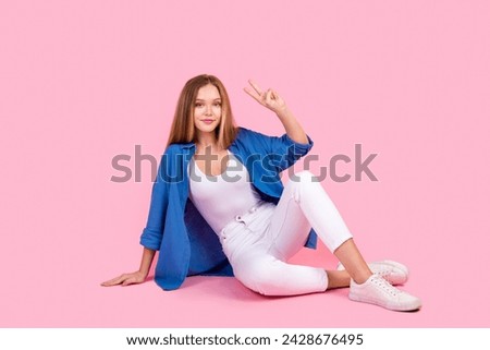 Full length photo of positive cool lady dressed blue shirt showing v-sign isolated pink color background