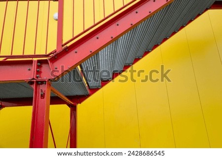 red escape staircase outside staircase on yellow wall industrial building