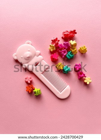 A set of accessories for a little girl on a pink background. Hairpins, combs, hair bands. Fashionable hair accessories for little girls. Flat styling. Top view