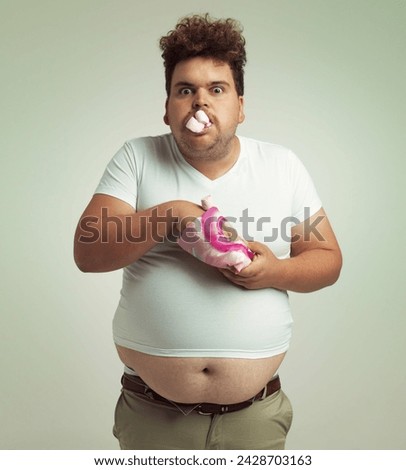 Must have more marshmallows. Shot of an overweight man with marshmallows shoved in his mouth. Royalty-Free Stock Photo #2428703163