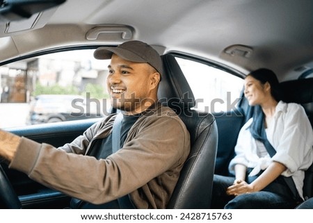 Young asian woman traveling in the downtown city with taxi driver service. Female passenger sitting in backseat calling taxi driver by application. Royalty-Free Stock Photo #2428715763