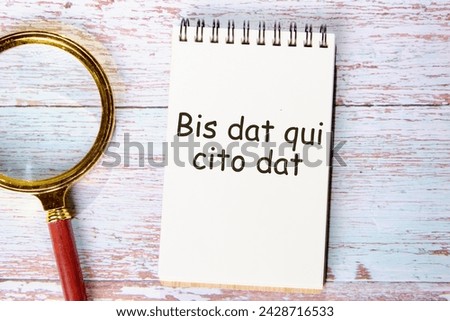 Bis dat qui cito dat It is translated from Latin as The one who gives twice is the one who gives quickly it is written on the page of the notebook