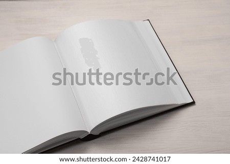 One open photo album on wooden table, above view