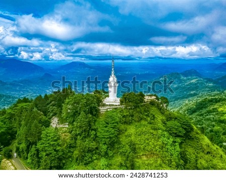 Top aerial drone view of Ambuluwawa Tower in Sri Lanka. The tower rises above the jungle on a high mountain. Temple on top of a mountain with a spiral staircase.