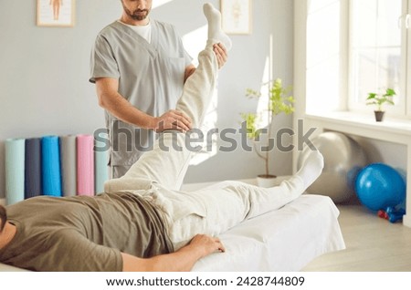 Skilled masseur provides a rejuvenating leg massage for a man on a therapy couch at a spa salon. Health focused treatment, expert techniques to enhance relaxation and well being. Royalty-Free Stock Photo #2428744809