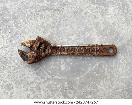 A rusted adjustable wrench with a well-worn grip and aged metal surface, showcasing signs of heavy use and long-term durability in mechanical work. Royalty-Free Stock Photo #2428747267