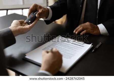 Customer signing car purchase or lease contract agreement with car salesman, car insurance.