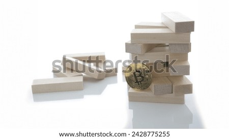 The bitcoin coin holds a game of wooden bricks embodying the basis of all the currency and exchange rate