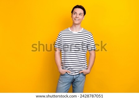 Portrait of optimistic student with brunet hair wear stylish t-shirt look at sale empty space isolated on vibrant yellow color background