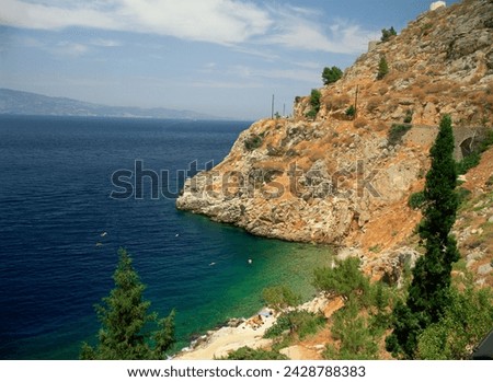 Swimmers in sea below cliffs on hydra, argo saronic islands, greek islands, greece, europe Royalty-Free Stock Photo #2428788383