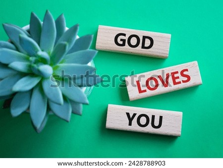 God loves you symbol. Wooden blocks with words God loves you. Beautiful green background with succulent plant. Religion and God loves you concept. Copy space.