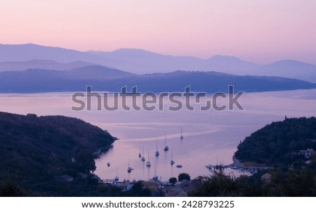 A view looking down on the harbour of ayios stefanos at sunrise, northeast coast, corfu, ionian islands, greek islands, greece, europe Royalty-Free Stock Photo #2428793225