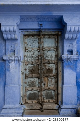 An old metal door of a traditional blue painted house in jodhpur, rajasthan, india, asia