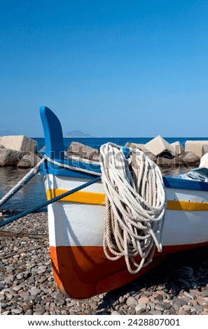 A colourful wooden fishing boat on the rocky beach at lingua, salina, the aeolian islands, off sicily, messina province, italy, mediterranean, europe