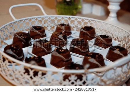 Mini bite-sized dark chocolate canapè mouse, sprinkled with nuts and chocolate shavings on vintage serving platter Royalty-Free Stock Photo #2428819517
