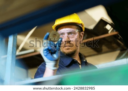 Senior professional electrical or industrial engineer inspecting and repairing a robotic system in the manufacturing factory close up. Robotic technician repairing - fixing a automated machine.