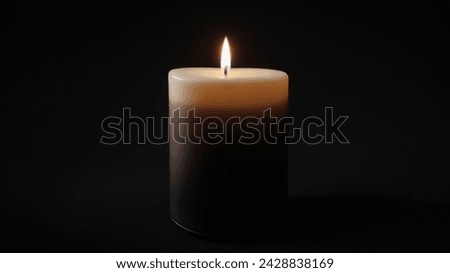 Burning candle on a black background. Close-up image.