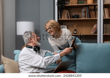 Simple living. Elderly retired couple enjoying their retirement, reminiscing entertaining in their warm home. Senior people evoking memories, happy people in cozy home, love and respect for each other Royalty-Free Stock Photo #2428841205