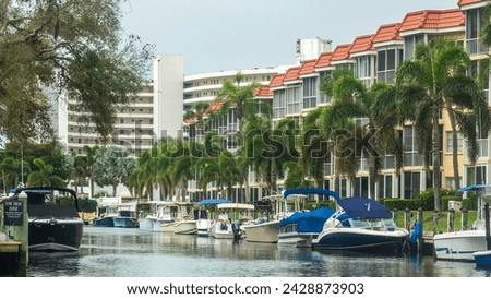 Residential inlet along the Intracoastal Waterway in Sarasota, Florida, with palm trees and other waterfront landscaping, upscale residences, and a row of motorboats for recreation and exploration Royalty-Free Stock Photo #2428873903