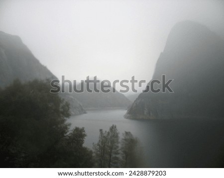 View of Hetch Hetchy water reservoir in a valley. Yosemite National Park. Beautiful foggy landscape photograph.	