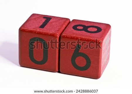 Number six and eighteen written on a red wooden cube of a calendar date.
