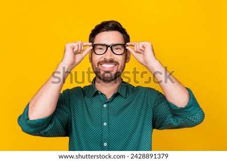 Portrait of optimistic man with beard wear stylish shirt two hands touch glasses at eyesight checkup isolated on yellow color background Royalty-Free Stock Photo #2428891379