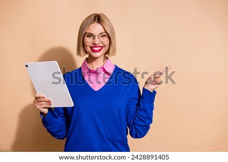 Photo of gorgeous girl hold tablet indicate finger empty space ad isolated on beige color background