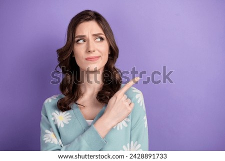 Portrait of young doubtful lady wear blue cardigan pointing finger nervous new boutique decrease price isolated on violet color background