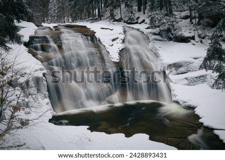 Mumlavsky waterfall. Winter forest. A frozen snowfall in a winter forest.