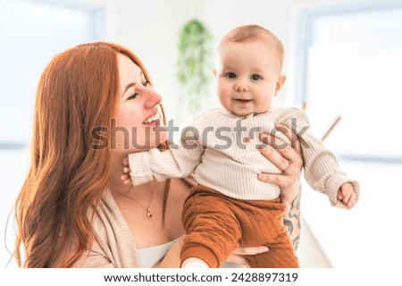 A young beautiful mother with a baby boy at home