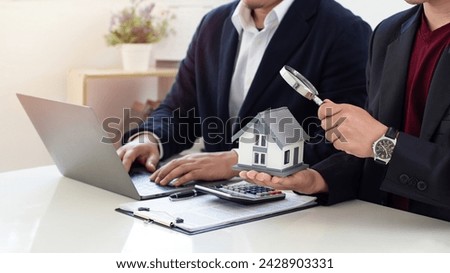 Real estate agents offer contracts to buy or rent housing. Businessman holding model small house and using a computer for property sales listings and choose a house buy online. investment. insurance.