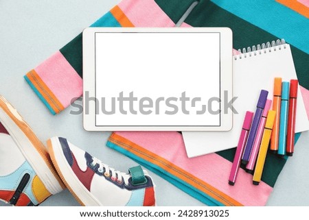 Modern tablet, clothes and stationery on light background, flat lay. Space for text