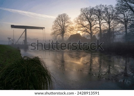 Bridge over a frozen canal near Heeten Royalty-Free Stock Photo #2428913591