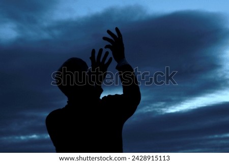 black man praying to god with arms outstretched looking up to the sky with people stock image stock photo